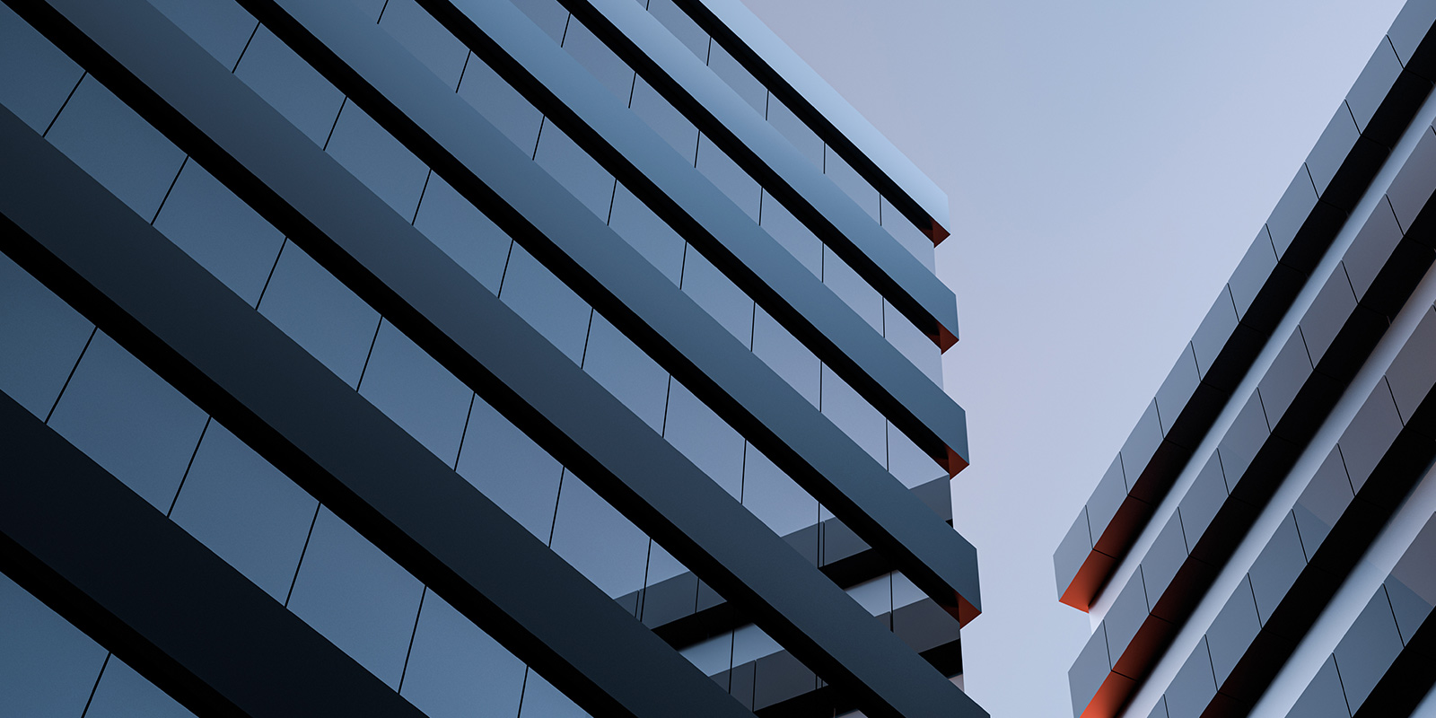 Two modern high-rise buildings with reflective glass, angled towards each other against a clear blue sky.