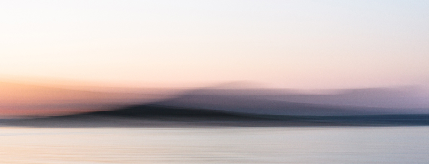 Abstract pastel landscape with blurred water, hills, and a soft pink-blue sky.