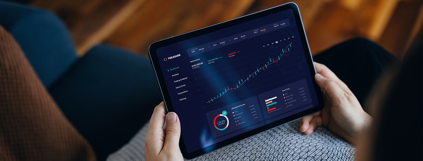 Person holding a tablet displaying a financial dashboard with performance metrics, portfolio details, and data trend graphs.