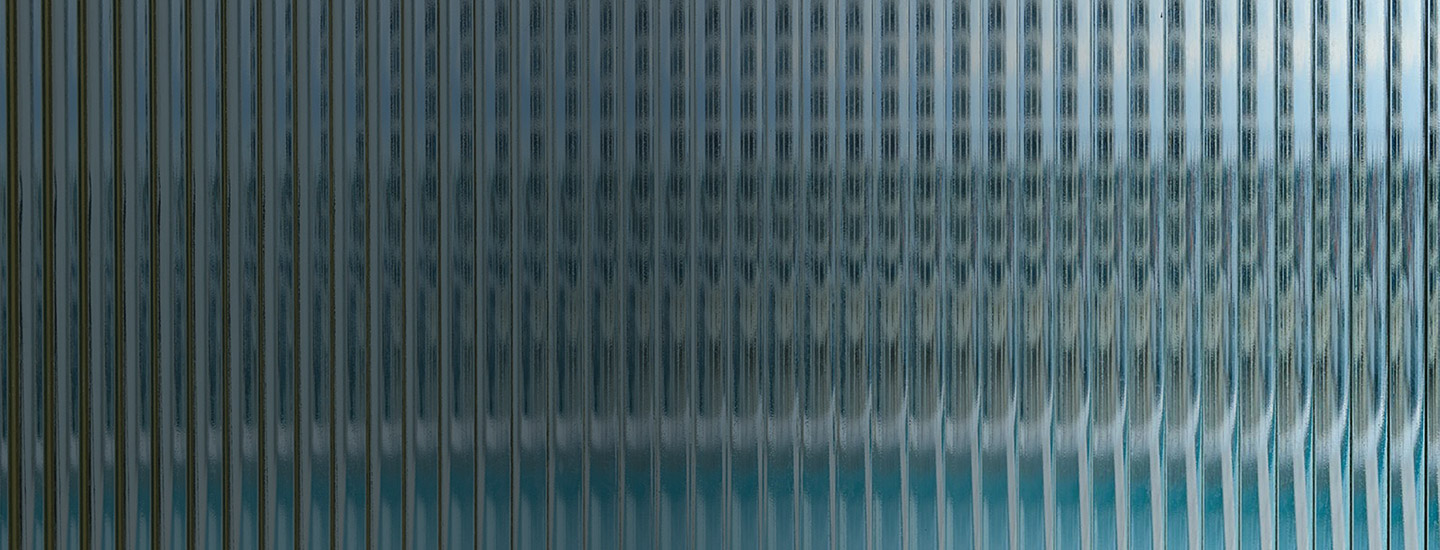 Distorted view with vertical lines, seen through textured glass.