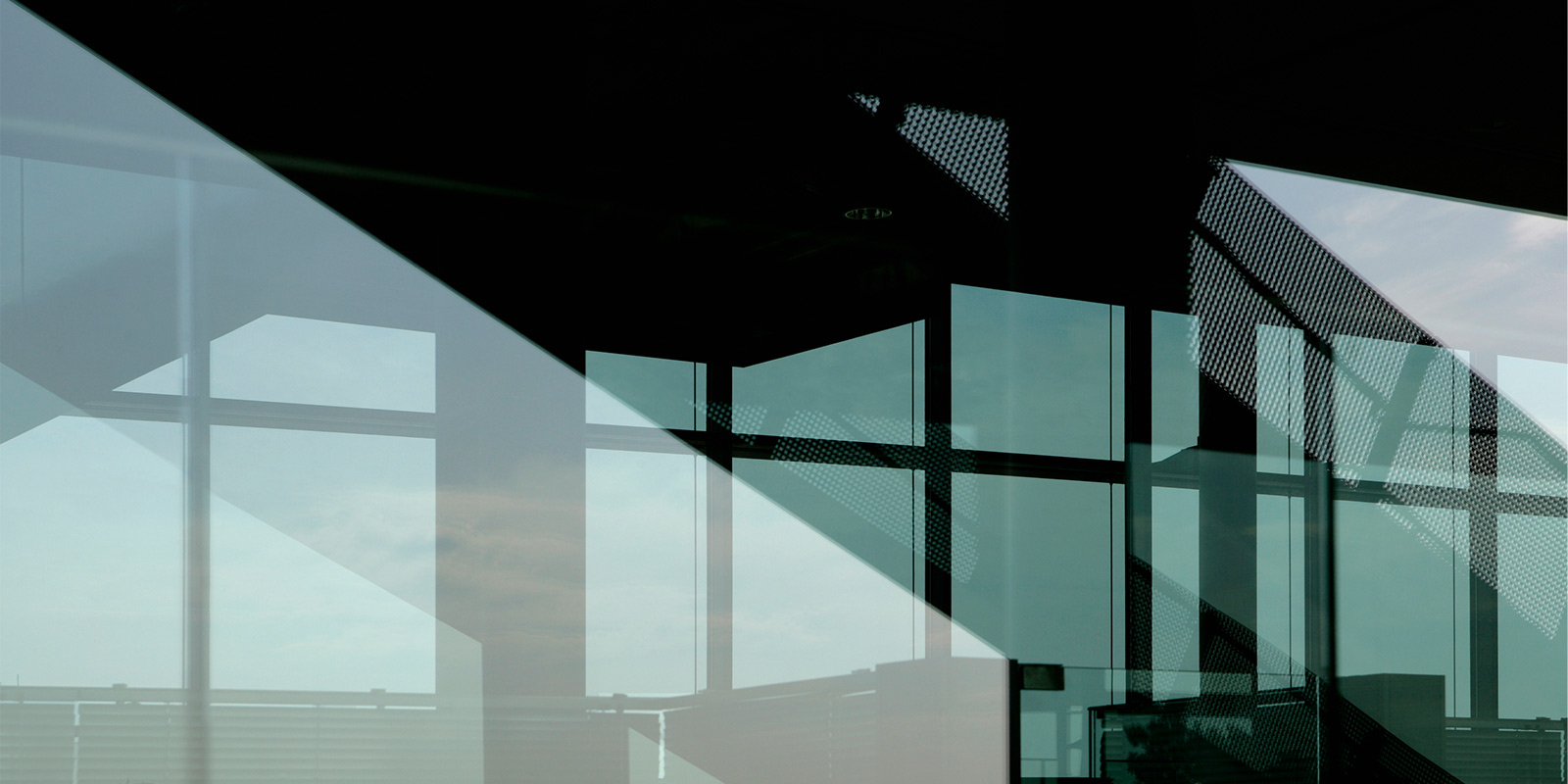 Modern architectural structure with large glass windows and metal framework.