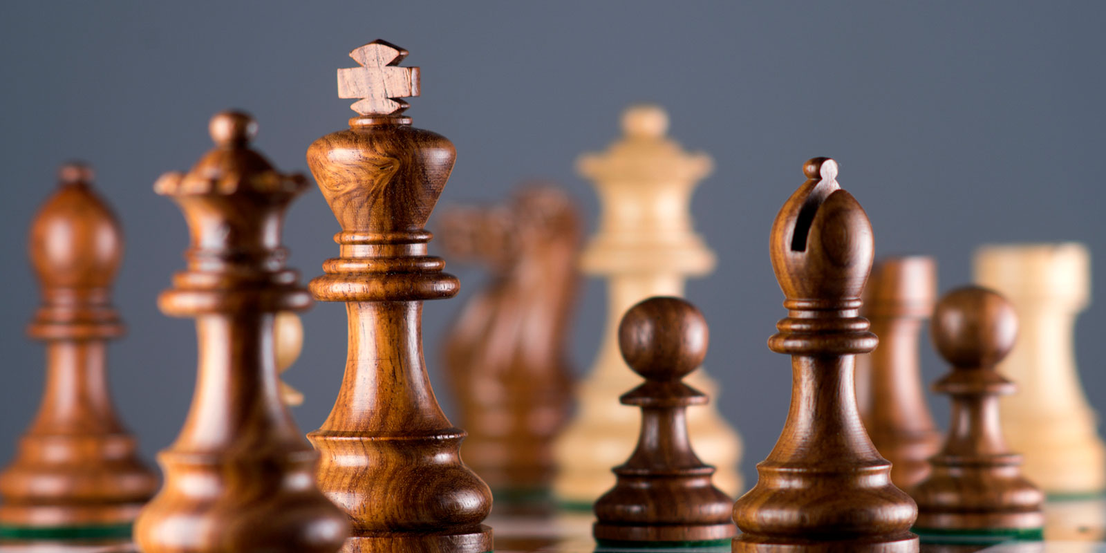 Close-up of wooden chess pieces on a chessboard.