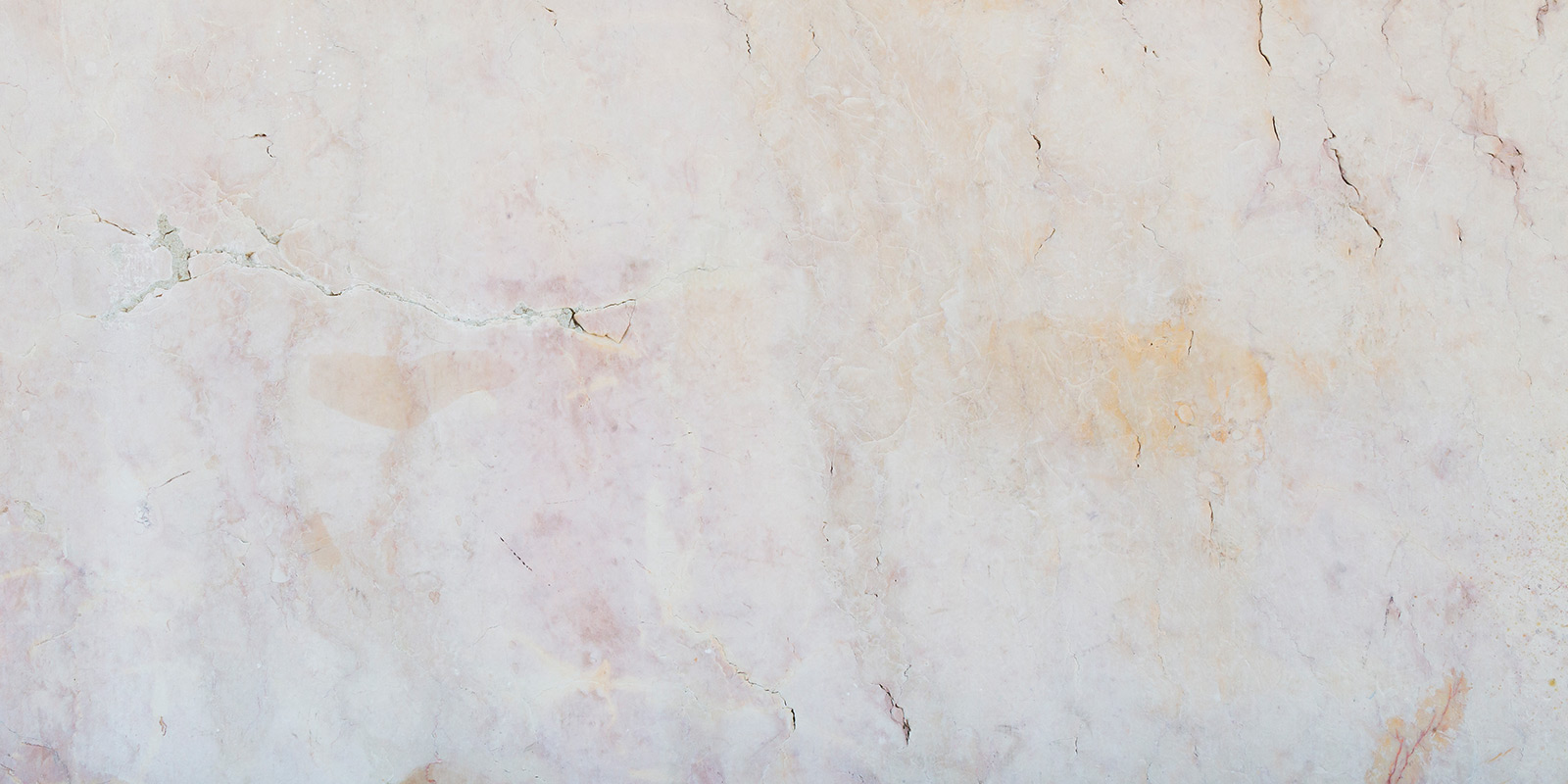 Light marble surface with natural veins and cracks.