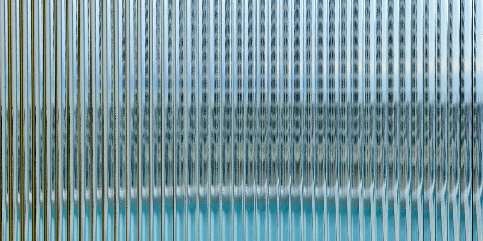 Abstract view through vertically ribbed glass.