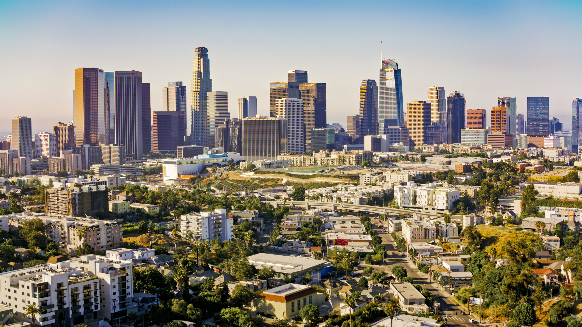 Panoramic cityscape with high-rises, mixed-use buildings, and a clear sky.